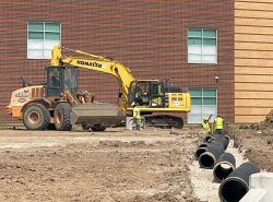 komatsu excavator and case roller beside drainage trench